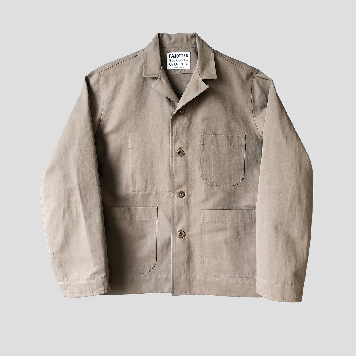 A light beige work jacket by Pajotten, featuring a collar, button-up front, chest pocket, and two lower patch pockets, laid flat against a light gray background.