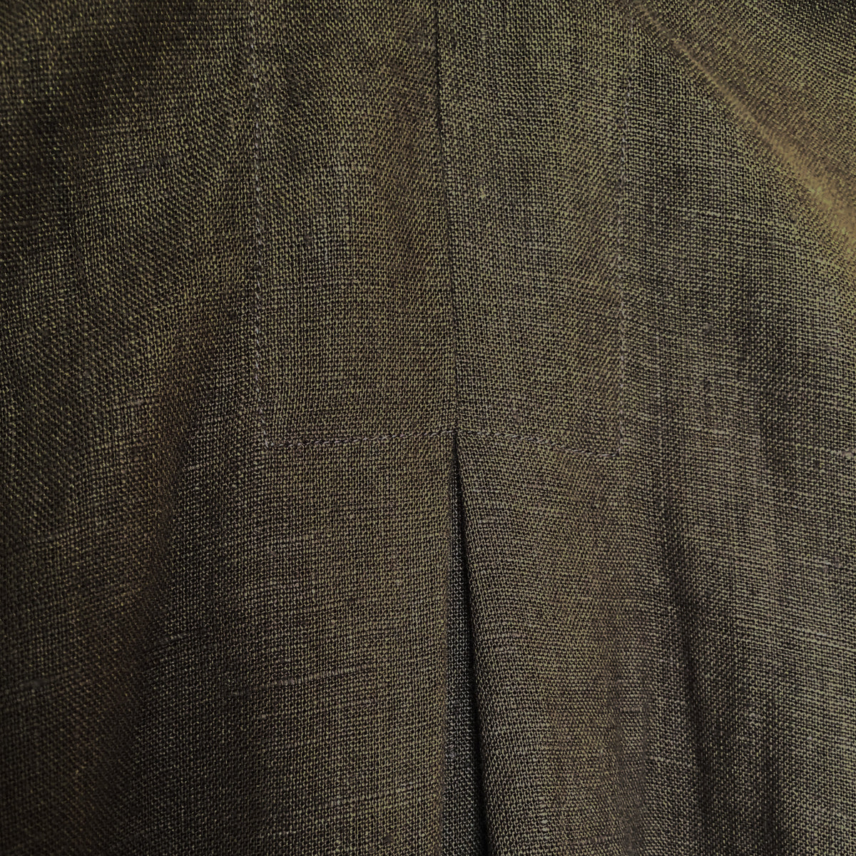Close-up of a dark olive-brown textured fabric with a central seam and fine woven detail.