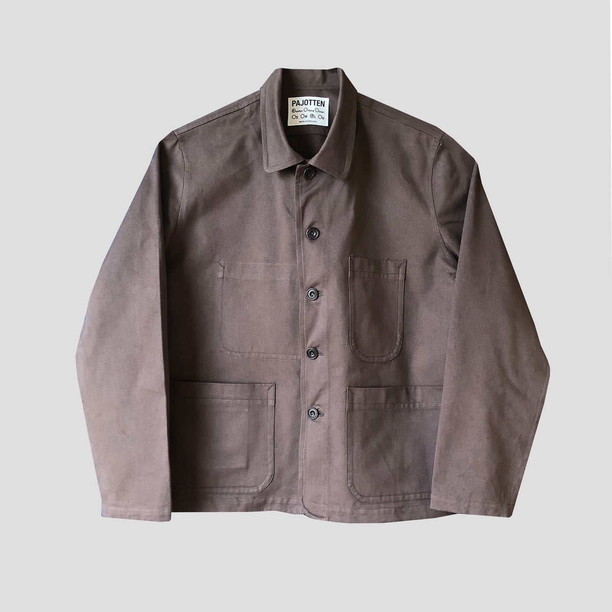 A dark brown cotton utility jacket with a button-up front, collar, chest pocket, and lower patch pockets, laid flat against a light gray background.