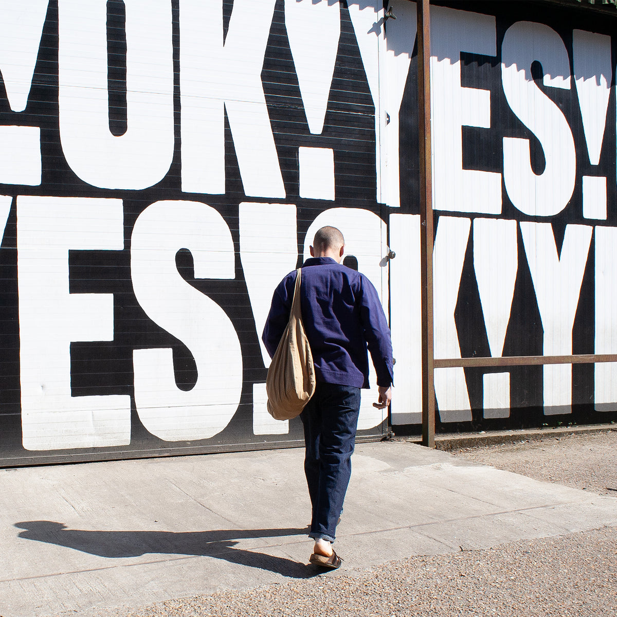 Person walking past a large mural with the word 'YES!' repeated.