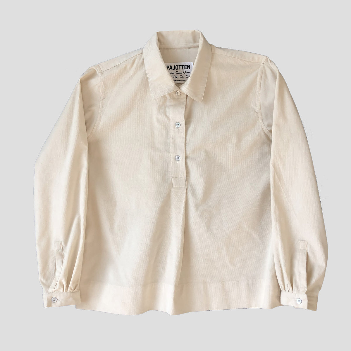 A cream-colored long-sleeve button-up shirt by PAJOTEN, laid flat against a light gray background.